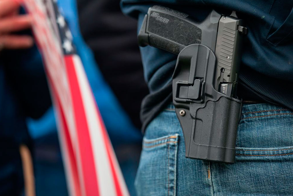 Gun in holster on mans pants, concealed carry insurance, firearms liability insurance