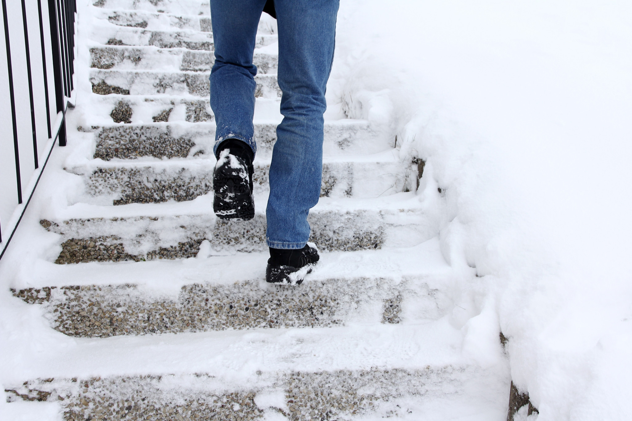 Man walking up snowy stairs | Wintertime business insurance